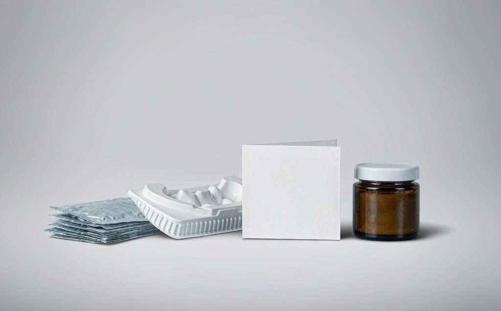 Teeth whitening strips in foil sachets with a whitening tray, instruction card and gel jar photographed in a clean B2B studio setting on a light grey background