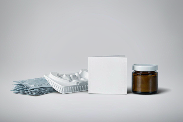 Teeth whitening strips in foil sachets with a whitening tray, instruction card and gel jar photographed in a clean B2B studio setting on a light grey background