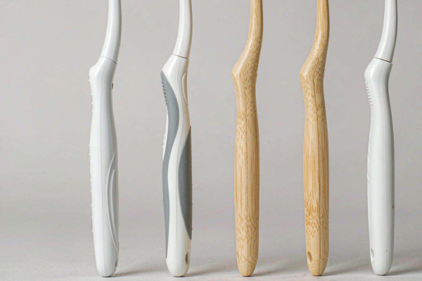 Assorted private label toothbrush handles in polypropylene, TPE-grip and bamboo on a light grey studio background